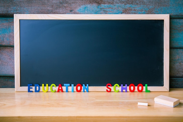 Magnet-Kreide-Tafel mit Buchstaben des Holzalphabets auf dem Tisch Kopieren Sie Platz für Design oder fügen Sie eine Textnachricht hinzu Bildungskonzept