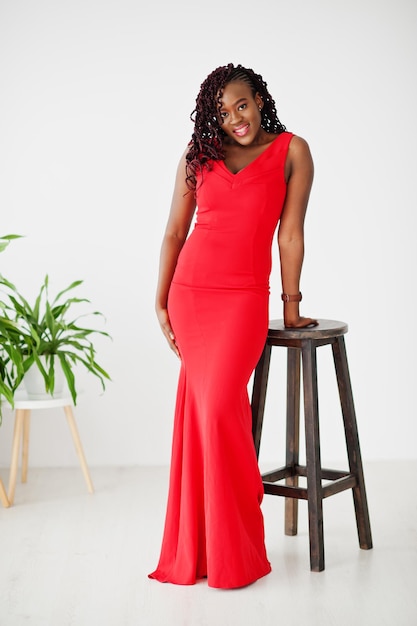Magnífica joven africana con un lujoso vestido rojo en un apartamento de lujo. Belleza, moda.
