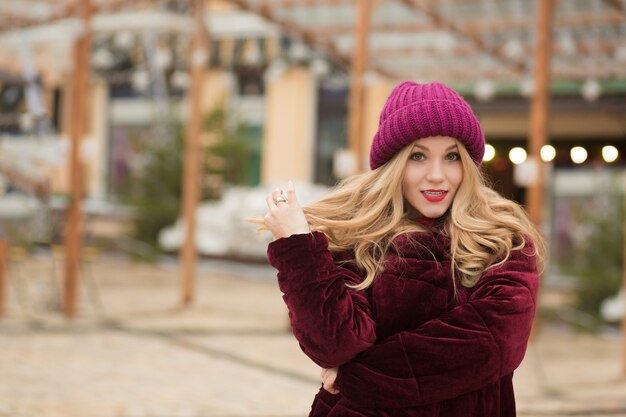 Magnífica mujer joven con cabello largo y exuberante posando en la calle en Kiev