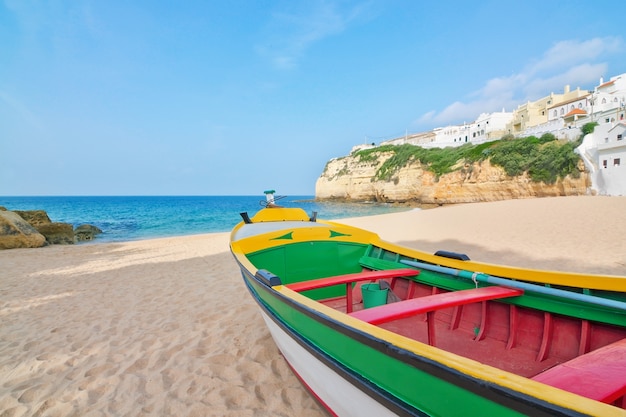 Magnífica playa en la costa de Portugal en Villa Carvoeiro. Barco de pesca en primer plano.