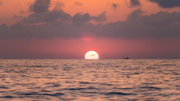 Magnífica puesta de sol sobre las suaves olas del cálido mar tropical