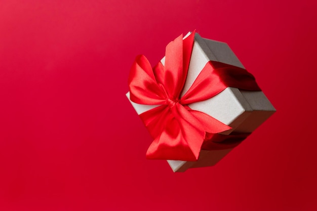 Magnífico banner festivo de Navidad o regalo de vacaciones de encabezado sobre fondo rojo Caja de regalo flotante de Navidad en rojo Temporada de vacaciones Año Nuevo Copiar espacio para texto