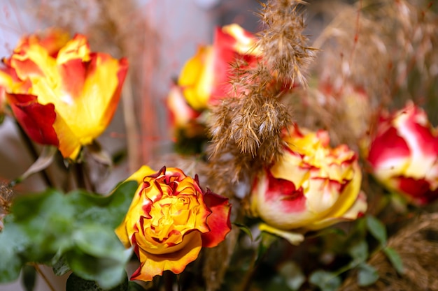 Magnífico y elegante ramo floral de hermosas rosas de color rojo anaranjado en jarrón en la mesa de fiesta