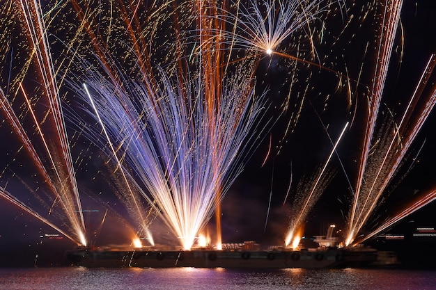 Magnífico espectáculo de fuegos artificiales multicolores en el cielo nocturno azul oscuro