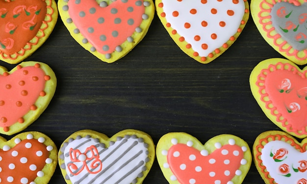 Magníficos marcos de galletas en forma de corazón naranja y amarillo sobre fondo negro