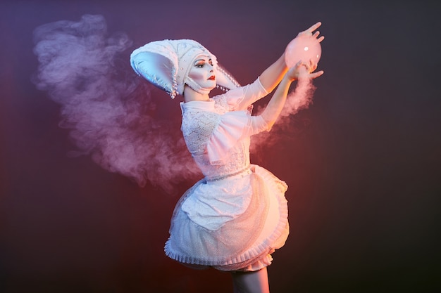 Mago de artista de circo muestra trucos con pompas de jabón. Mujer y una niña inflan pompas de jabón