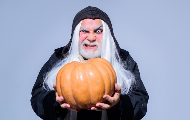 Foto mago malvado mantenga naranja calabaza hombre maduro mago con sombrero de bruja comida tradicional fantasía horror