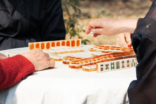 Mahjong jogo de mesa de jogo do chinês sênior na rua da cidade