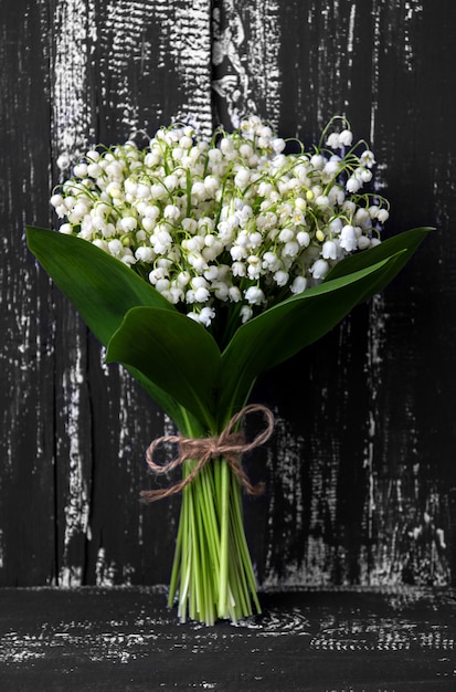 Maiglöckchen auf hölzernem Hintergrund. Maiglöckchen Bouquet. Platz für Text.