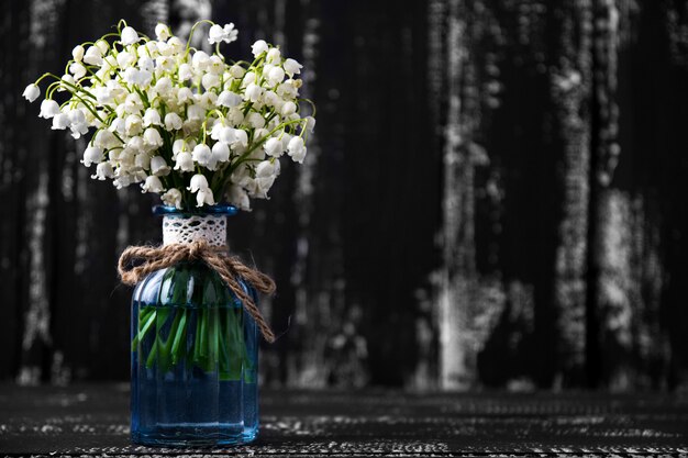 Maiglöckchen auf hölzernem Hintergrund. Maiglöckchen Bouquet. Platz für Text.