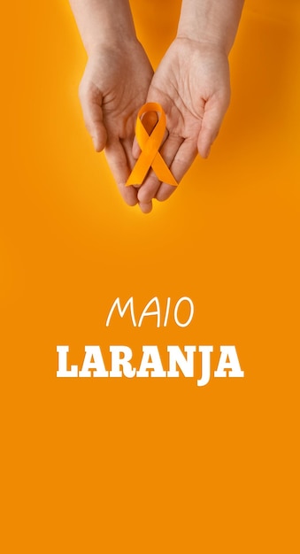 Maio laranja Mãos segurando uma fita laranja Proteção de crianças e adolescentes contra a violência