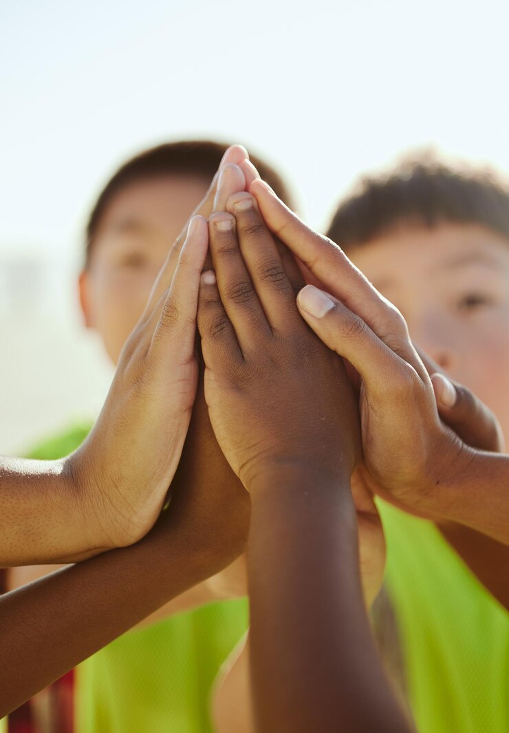Foto mais cinco amigos e mãos de crianças em apoio ao trabalho em equipe da comunidade e ao projeto de limpeza as crianças se juntam para colaborar com a equipe de voluntários, reunindo ajuda, motivação e solidariedade