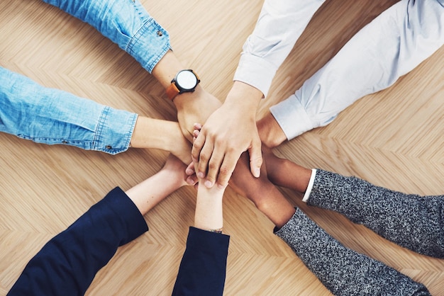 É mais fácil se fizermos isso juntos Foto de alto ângulo de um grupo de empresários não identificáveis juntando as mãos em união