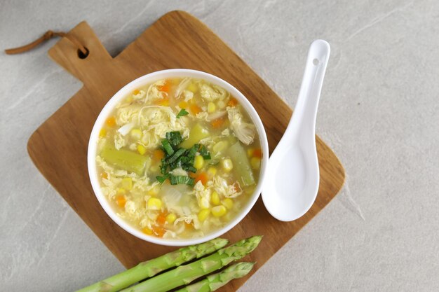 Mais-Spargel mit Eiertropfensuppe in weißer Schale und knusprigem Brot