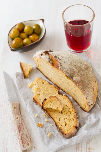 Maisbrot mit Oliven und Rotwein auf Papier