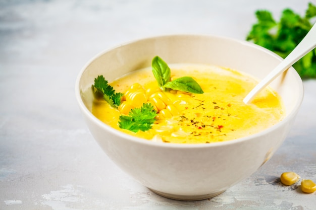 Maiscremesuppe des strengen Vegetariers in der weißen Schüssel auf einem Grau