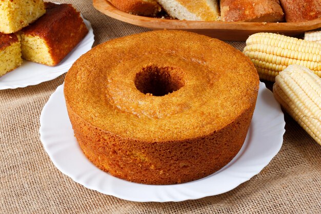 Foto maiskuchen auf einem weißen teller auf einem rustikalen holztisch typische brasilianische partygerichte