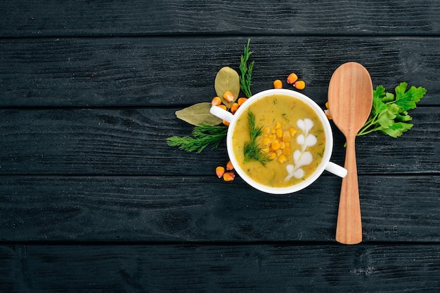 Maissuppe mit frischem Gemüse in einer Schüssel Gesundes Essen auf schwarzem Hintergrund aus Holz Draufsicht Kopieren Sie Platz für Ihren Text