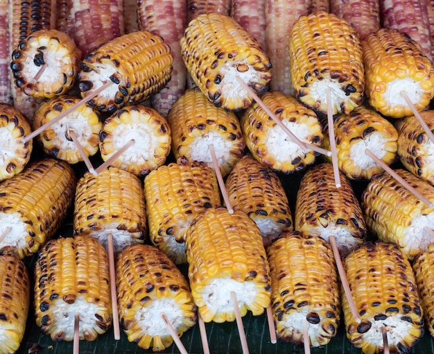 Maíz dulce asado con el pincho de madera.