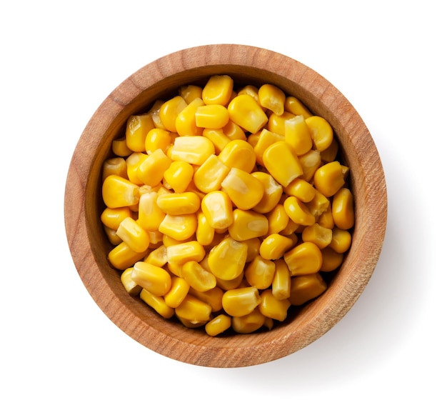 Foto maíz enlatado en un plato de madera sobre un fondo blanco vista superior