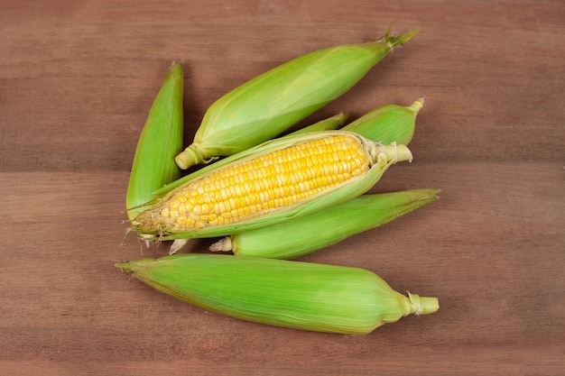 Maíz de maíz o mazorcas de maíz frescos orgánicos en la madera. Comida para la salud.