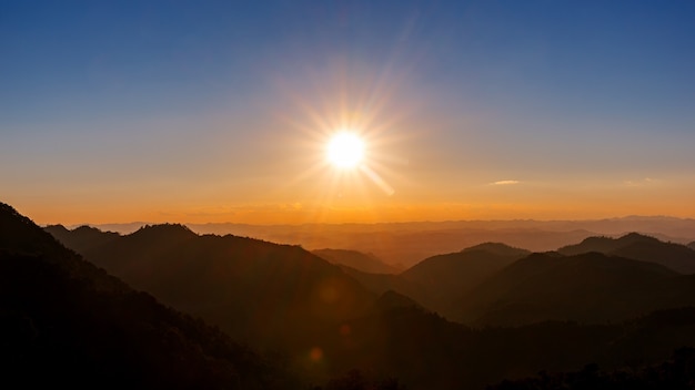 Majestätischer Sonnenunterganghimmel über blauer Gebirgslandschaft