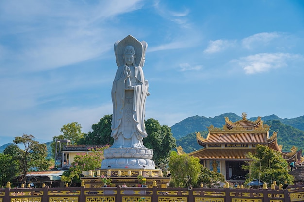 Foto majestosa estátua branca de buda no fundo do céu azul a senhora buda o bodhisattva da misericórdia no pagode buu lam tu que atrai turistas para visitar espiritualmente nos fins de semana em vung tau vietnam