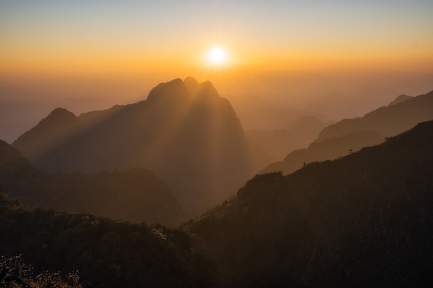 Majestoso pôr do sol na paisagem de montanhas com vigas ensolaradas