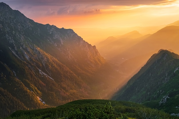 Majestuosa puesta de sol dorada con rayos de sol en el paisaje de la gran montaña. Parque nacional de los Altos Tatras, Polonia