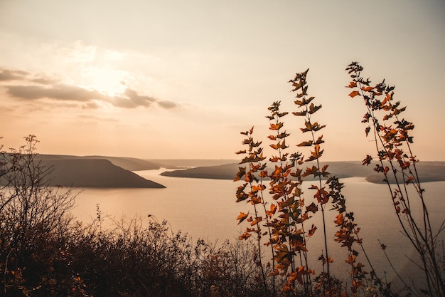 Foto majestuosa puesta de sol en el paisaje de las montañas sobre un lago tranquilo.