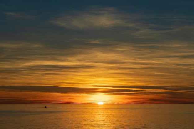 Majestuosa vista de una puesta de sol con una superficie de agua de mar