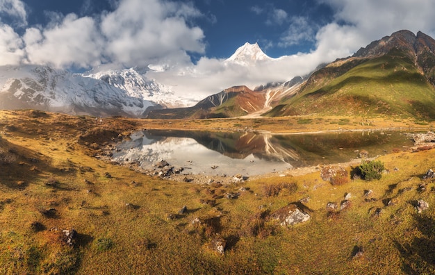 Majestuosas montañas con altas rocas y lago al atardecer