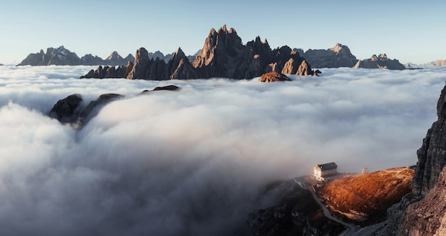 Majestuosas montañas. Ruta de senderismo que va cerca de la colina con niebla al edificio vivo. Foto panorámica