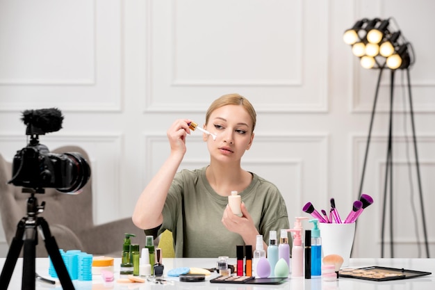 Make-up-Blogger erstellt Make-up-Tutorial vor der Kamera junges süßes hübsches Mädchen, das Creme aufsetzt