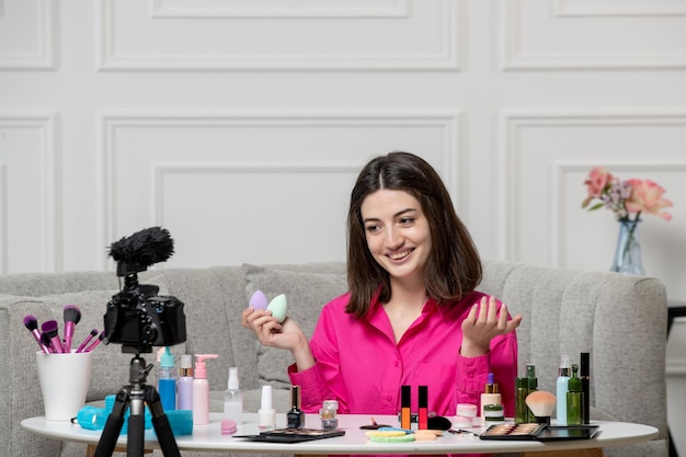 Make-up-Bloggerin, niedlich, schön, schöne junge Dame, die Blogs vor der Kamera mit Schwämmen aufnimmt