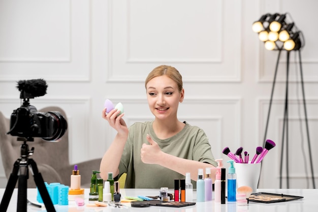 Make-up-Bloggerin, süßes, hübsches junges Mädchen, das Make-up-Tutorial vor der Kamera aufzeichnet, glücklich