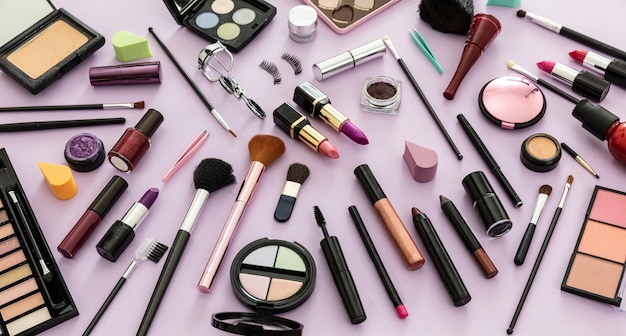 Make-up-Kosmetika gegen einen pastellvioletten Hintergrund