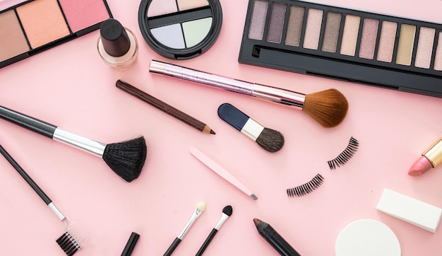 Make-up-Kosmetika gegen einen rosa Hintergrund