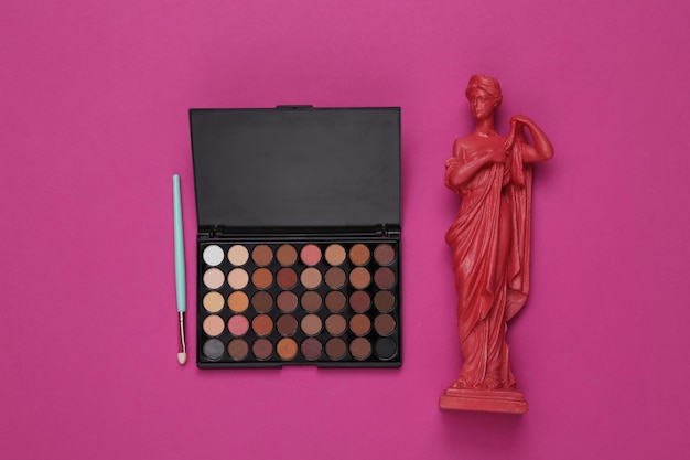 Make-up-Palette Lidschatten mit antiker Statue auf rosa Hintergrund Schönheits-Glamour-Szene Draufsicht