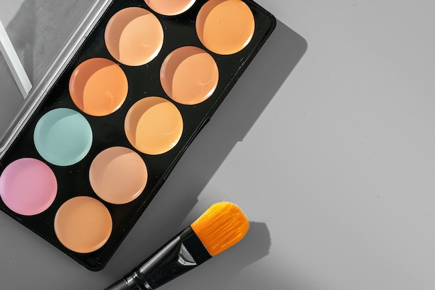 Make-up-Palette mit bunten Concealern auf grauem Hintergrund