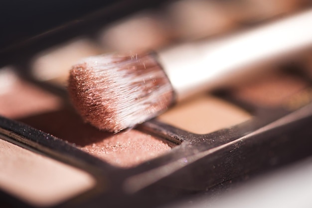 Make-up-Pinsel auf Lidschatten-Palette Nahaufnahme. Selektiver Fokus.