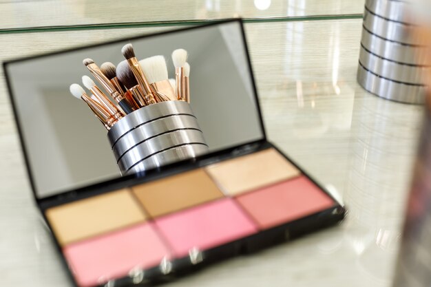 Make-up Pinsel werden in einem Palettenspiegel mit Schatten reflektiert