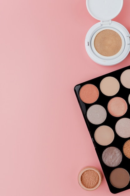 Make-up-Produkte auf rosa Hintergrund. Draufsicht mit Kopierraum
