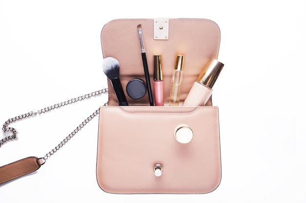 Make-up-Produkte mit Kosmetiktasche auf weißem Hintergrund