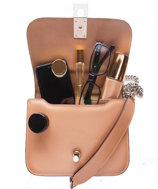 Make-up-Produkte und Handy in trendiger Handtasche auf weißem Hintergrund Nahaufnahme