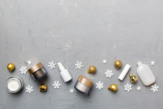Make-up-Produkte und Weihnachtsschmuck auf farbigem Hintergrund. Draufsicht Neues Jahr Schönheitskonzept mit Kopienraum