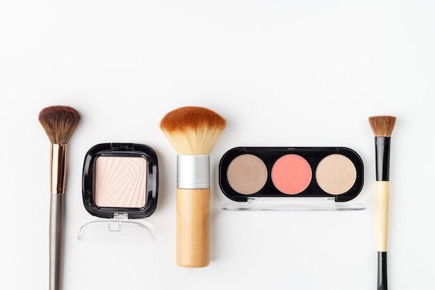 Make-up Puder und Pinsel isoliert auf weiß