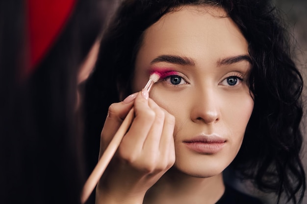 Make-up talentierter Künstler, der Frau Maquillage macht