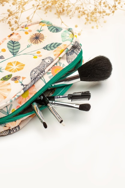 Make-up-Tasche mit Make-up-Pinseln auf weißem Hintergrund mit Kopierraum