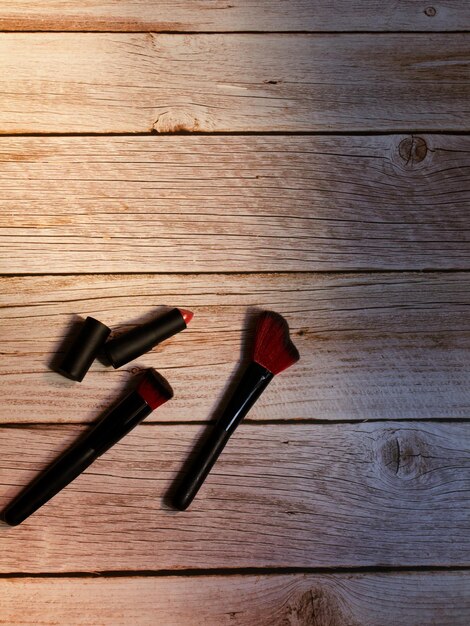 Make-up- und Lippenstiftpinsel auf Holz